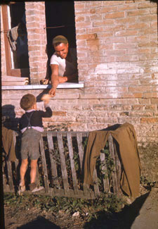 Photo montrant un militaire canadien offrant des biscuits à un enfant, vers 1944.