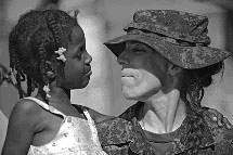 Captain Lyne Poirier of 5 Canadian Mechanized Brigade Group holds an orphaned girl in the aftermath of the earthquake in Haiti.